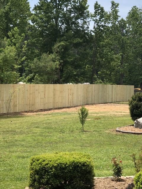 Wood fence bordering a landscaped property