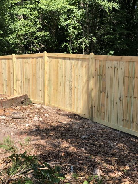 Wood privacy fence along a driveway