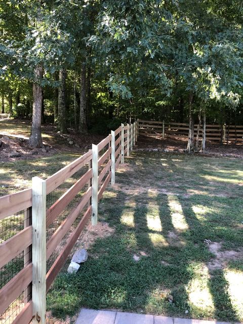 Split-rail wood fencing across open acreage